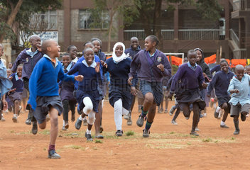 Nairobi  Kenia - Schueler und Schuelerinnen in Schuluniformen laufen auf dem Schulhof des St. John’s Community Centers Pumwani um die Wette.