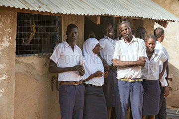Kakuma  Kenia - Schueler und Schuelerinnen stehen vor einem Schulgebaeude im Fluechtlingslager Kakuma.