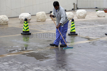 Doha  Katar  Mann reinigt einen Parkplatz