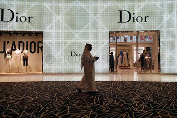 Dubai  Vereinigte Arabische Emirate  Mann in Landestracht laeuft an einer Filiale von Christian Dior vorbei