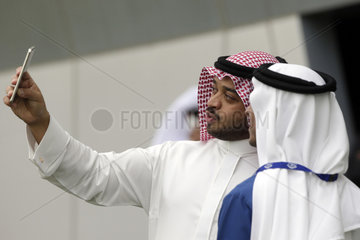 Dubai  Maenner in arabischer Tracht machen ein Selfie