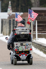 20.09.2017  Neuenhagen  Mann faehrt sein mit USA Fahnen geschmueckten Elektro Rollstuhl am Tag der Vereidigung von US Praesident Donald Trump
