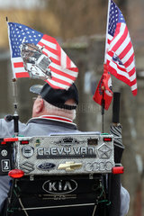 Neuenhagen  Deutschland - Mann mit US-Fahnen in einem Elektro-Rollstuhl