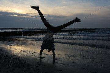 Wustrow  Deutschland - Silhouette  Junge macht am Strand einen Handstand