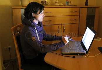 Melbeck  Deutschland - Frau sitzt vor ihrem Laptop