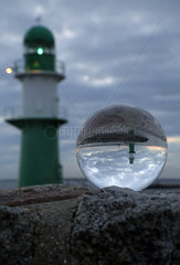 Warnemuende  Leuchttuerme an der Mole spiegeln sich bei Daemmerung in einer Glaskugel