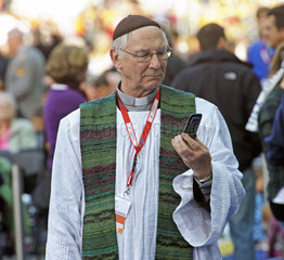 Priester mit Handy