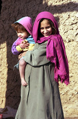 Maedchen mit einem Kleinkind auf dem Arm in Kunduz