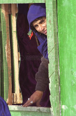 Frau schaut aus einem Fenster im Dorf Baluc