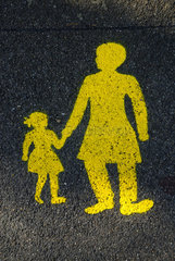Gelbes Mutter und Kind Zeichen auf einer nassen Strasse in der Schweiz in Bern.