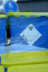 Biohazard Zeichen auf blauen Faessern mit medizinischen Abfaellen.