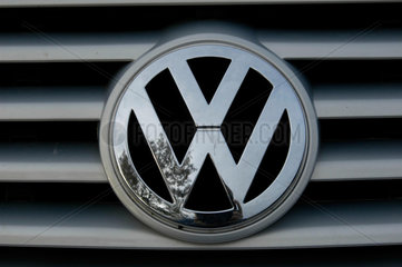 Ein VW-Schriftzug am Kuehlergrill eines Personenwagens.