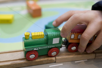 Kinderhand mit Spielzeugeisenbahn