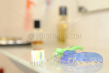 Zahnspange und Zahnbuerste im Badezimmer