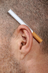Zigarette hinter das Ohr geklemmt