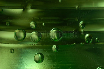 Kohlensaeure - Blasen in einer gruenen PET - Flasche.