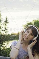 Young woman listening to music through headphones