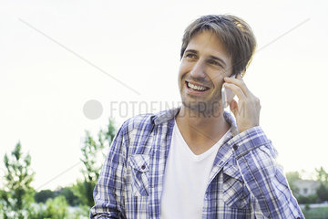 Man taking phone call on cell phone while enjoying being outdoors