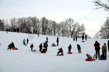 Winterlandschaft mit Schlitten- und Skifahrern
