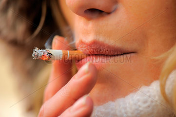 Junge Frau raucht eine Zigarette.