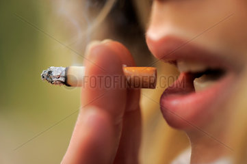 Junge Frau raucht eine Zigarette.