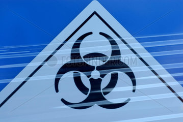 Biohazard Zeichen auf blauen Faessern mit medizinischen Abfaellen.
