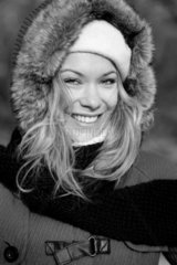 Lachende junge Frau in Winterkleidern.