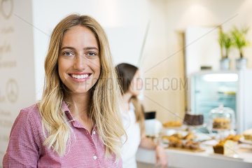 Young woman smiling cheerfully in bakery  portrait