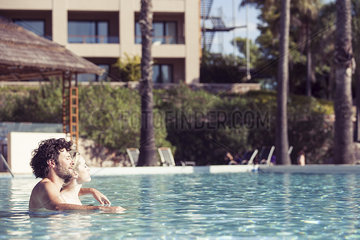 Couple relaxing in pool at luxury resort