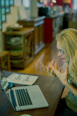 Woman using laptop computer and gesturing in frustration