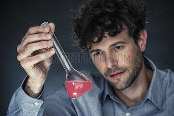 Man looking at liquid in conical flask