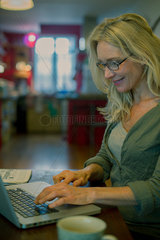 Mature woman using laptop computer at home
