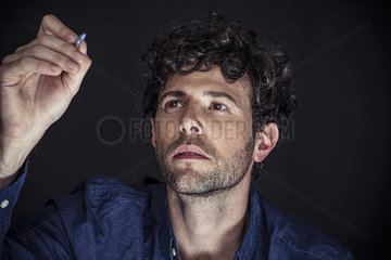 Man using stylus to write on transparent screen