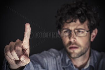 Man using index finger on transparent touch screen