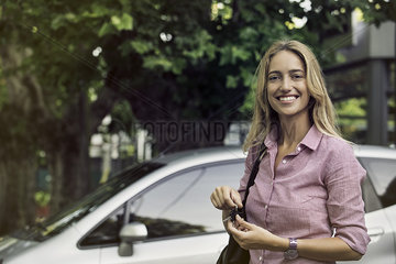 Young woman holding car keys  smiling cheerfully