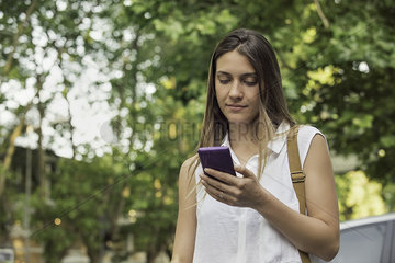 Young woman checking smartphone outdoors