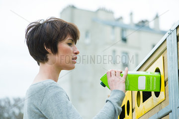 Woman placing carton in recycling bin
