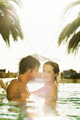 Couple relaxing together in resort swimming pool