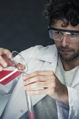 Scientist pouring liquid into test tube