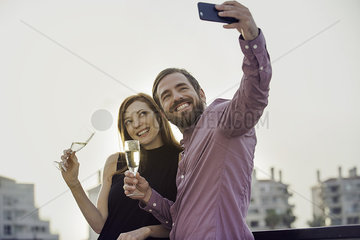 Couple posing with champagne for selfie