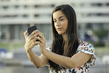 Woman taking selfie using smart phone