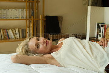 Mature woman lying on bed  portrait