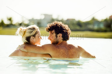 Couple relaxing in water and gazing into each other's eyes
