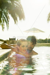 Couple relaxing together in resort swimming pool