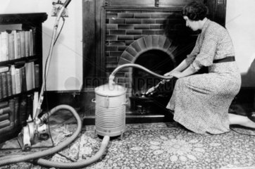 Woman vacuuming the fireplace  7 March 1936.