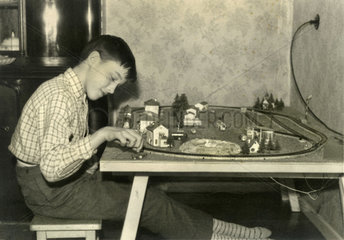 Junge spielt mit Modelleisenbahn  1958