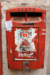 Italy. Sardinia - red postbox with communist sticker