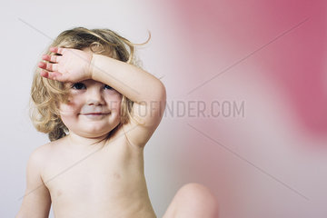 Little girl holding arm over face  portrait