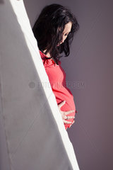 Pregnant woman holding stomach  looking down