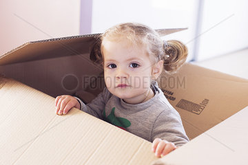 Little girl playing in cardboard box  portrait